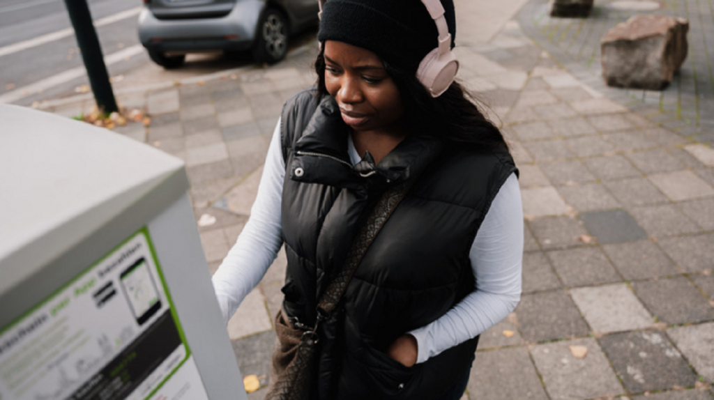 Black woman with headphones at ATM